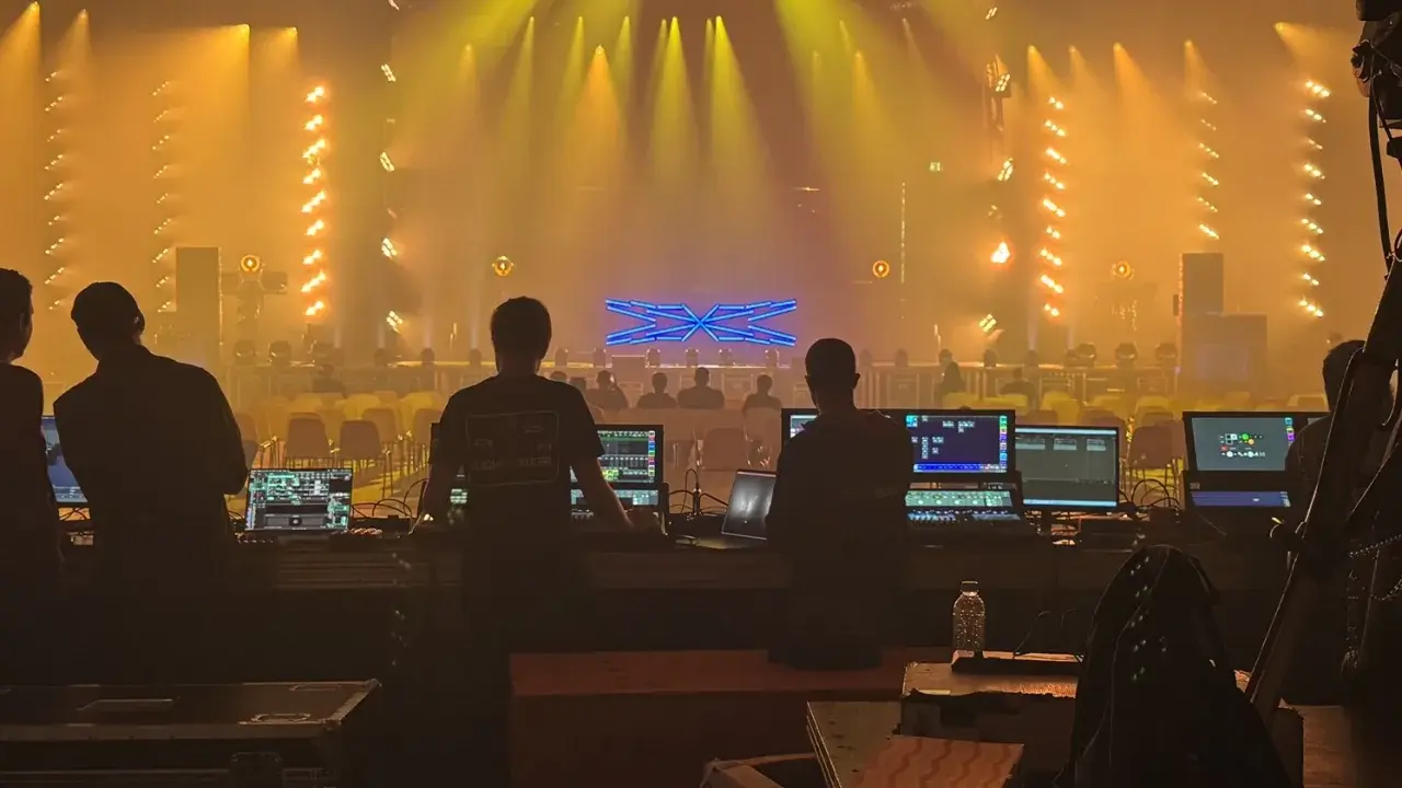 Tecnici al lavoro con console luci e schermi, pronti per un grande evento al MIR Rimini.