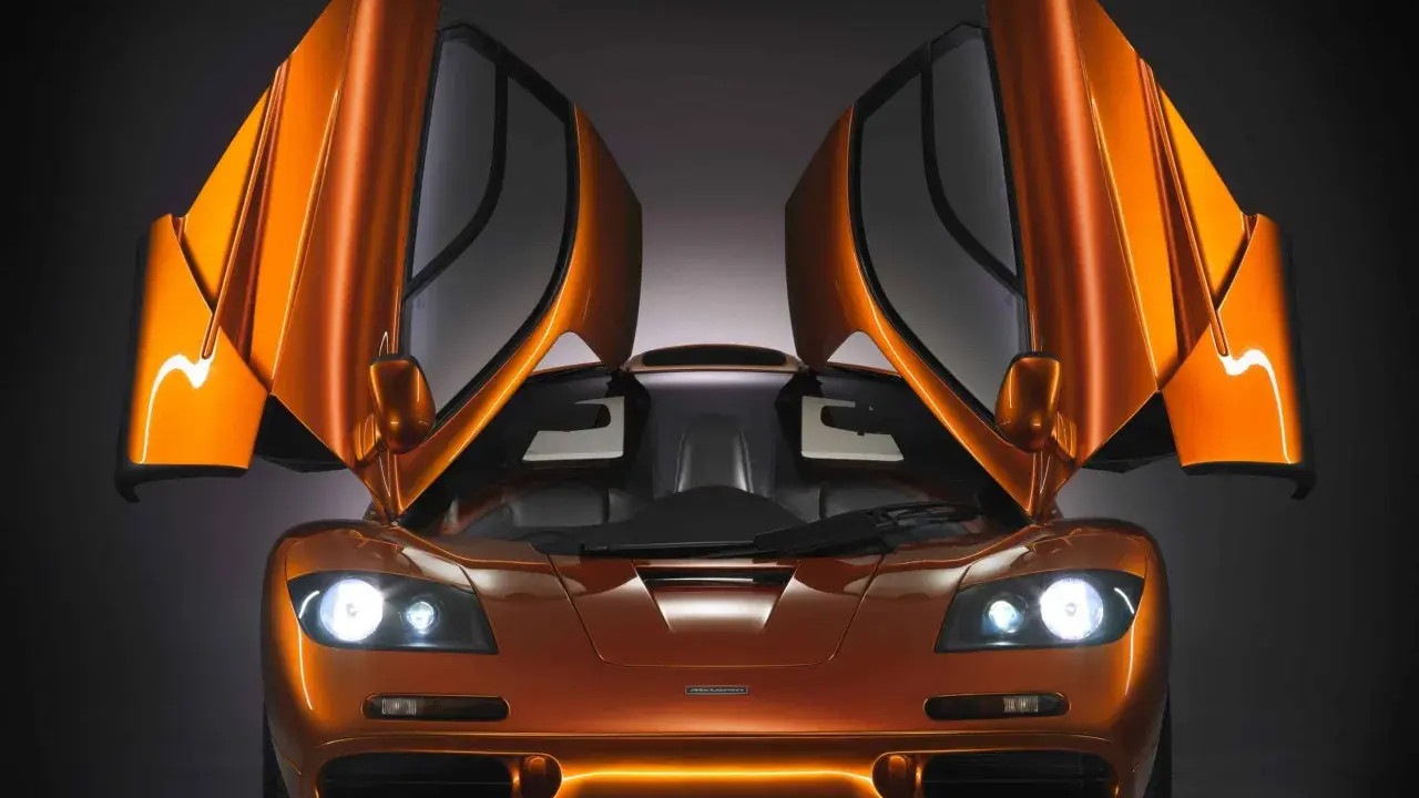 Orange McLaren F1 mit geöffneten Flügeltüren. Ein Traumauto, dessen McLaren F1 Preis unbezahlbar ist.