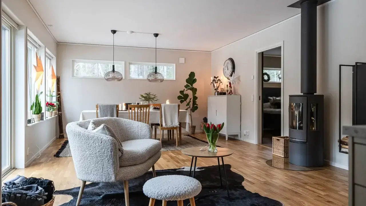 Mysigt vardagsrum inspiration med en fluffig fåtölj, kamin och matplats. Perfekt för kalla kvällar.