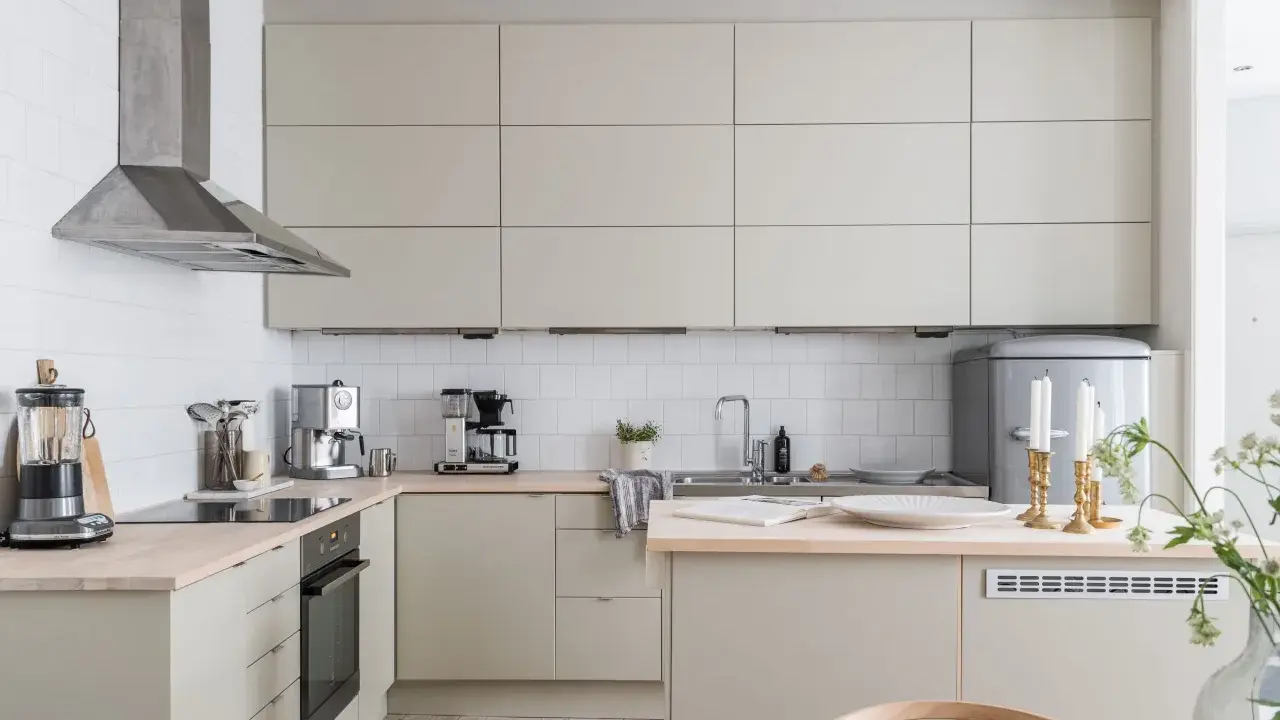 Beżowa kuchnia inspiracje: minimalistyczne szafki, drewniany blat, stalowy okap i eleganckie dodatki tworzą przytulną atmosferę.