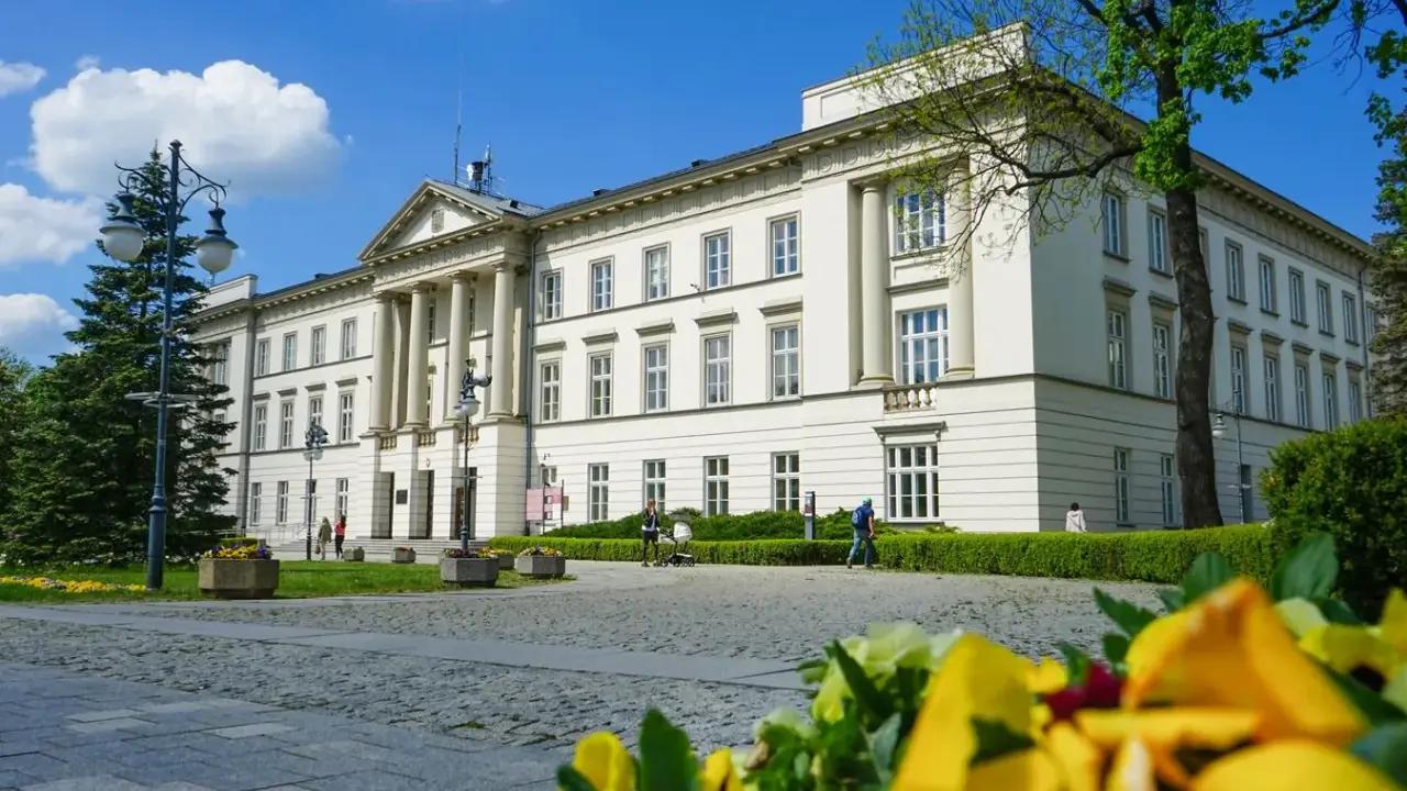 Piękny budynek w Radomiu, jedna z jego atrakcji, z kolumnami i zielenią.