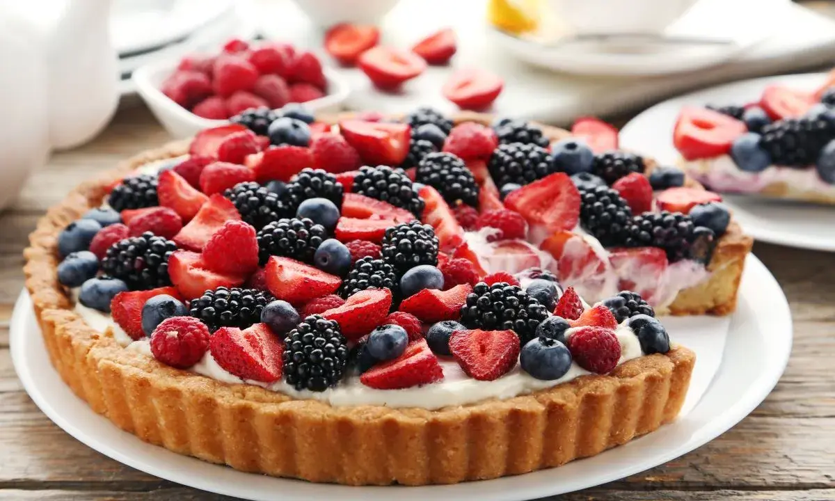 Tarta na cieście francuskim, obficie udekorowana świeżymi truskawkami, malinami, jeżynami i borówkami. Pyszny deser na letnie popołudnie.