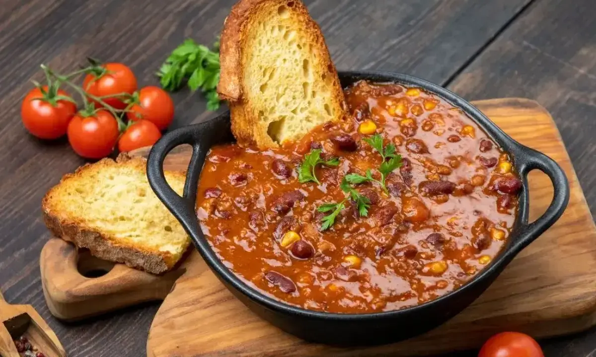 Gęste chili con carne z fasolą i kukurydzą, podane z chrupiącym pieczywem. Idealny obiad na dwa dni, który rozgrzeje i nasyci.