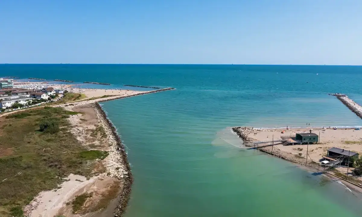 Lido di Savio, Milano Marittima: un'insenatura con moli frangiflutti e stabilimenti balneari affacciati sul mare Adriatico.