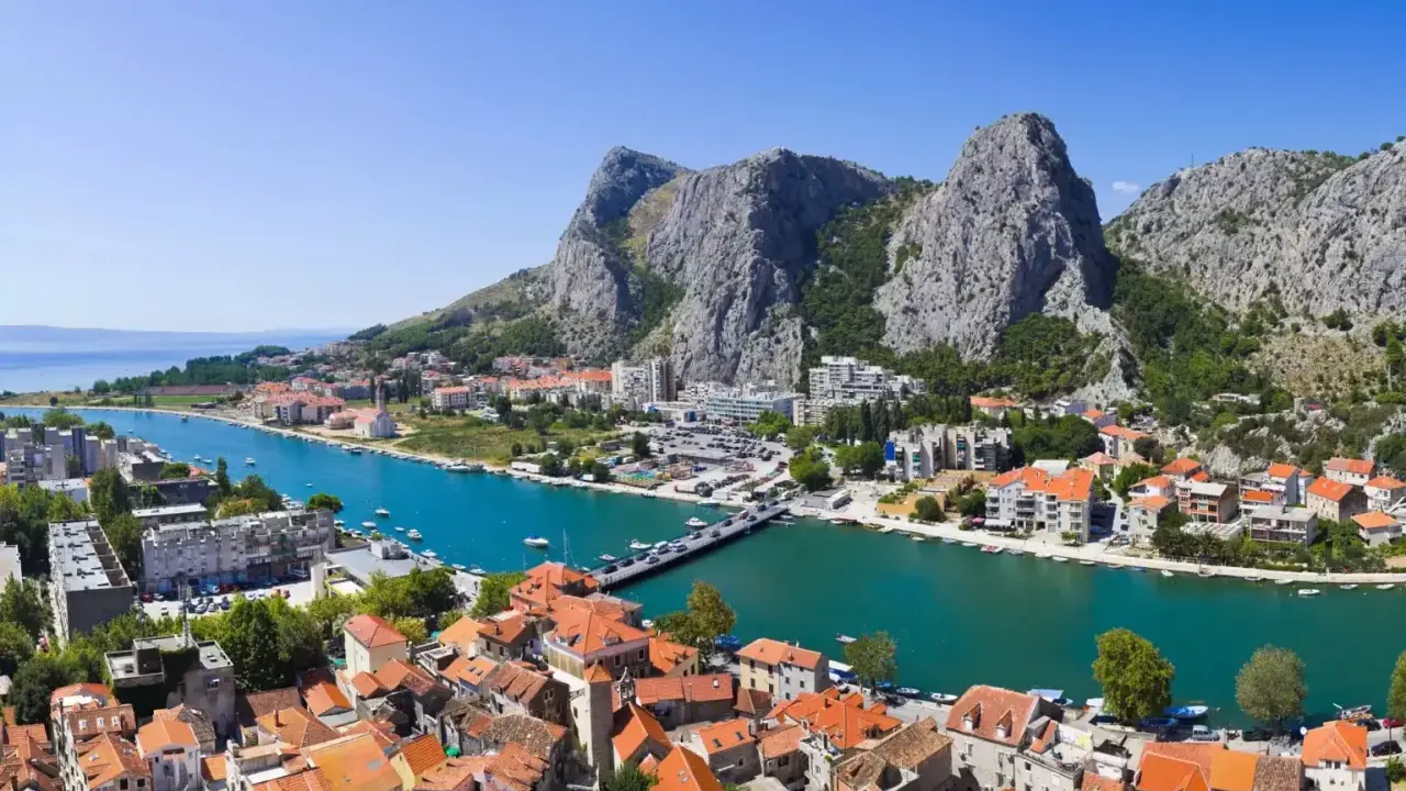 Widok na miasto Omis w Chorwacji z rzeką Cetina i górami w tle.