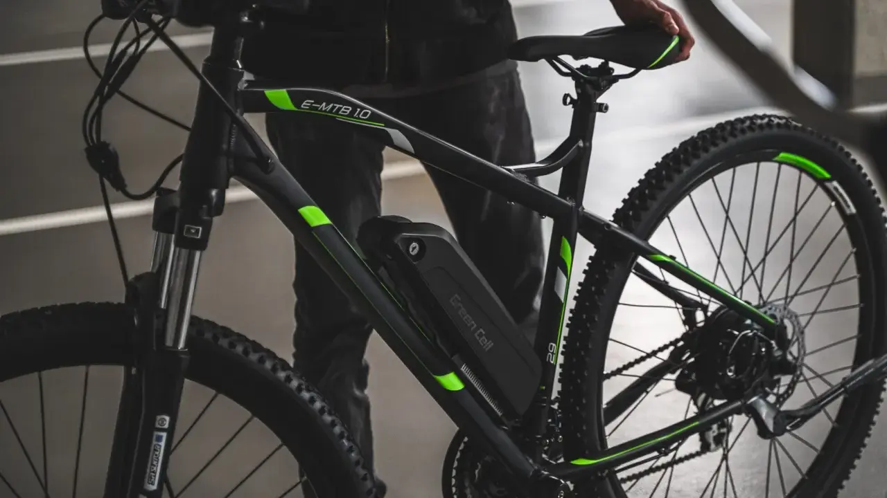 Czarny rower elektryczny z zielonymi akcentami i baterią Green Cell. Dowiedz się, jak sprawdzić baterię w rowerze elektrycznym.