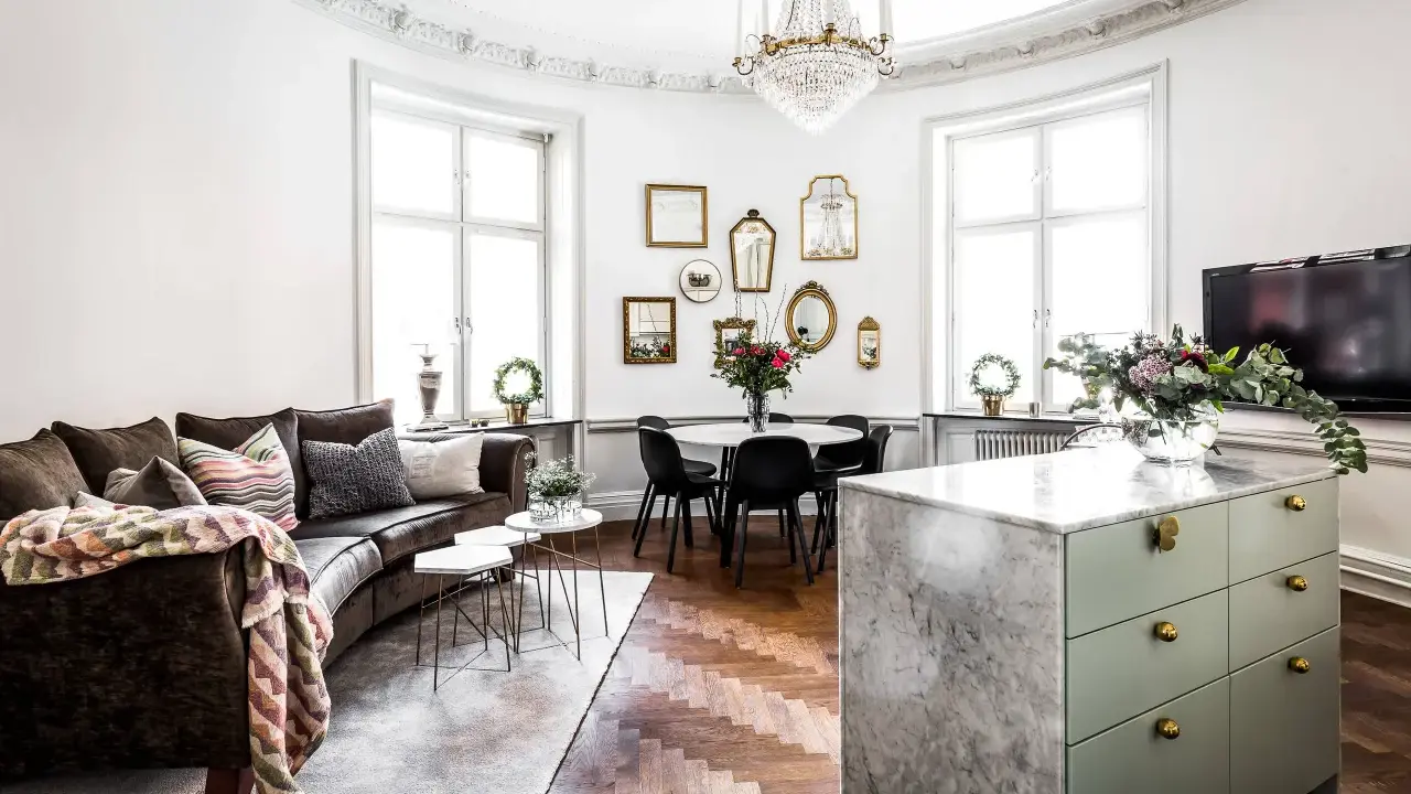 Ett vardagsrum med mörk soffa, marmorö, och en matplats. Massor av speglar på väggen ger inredning inspiration.