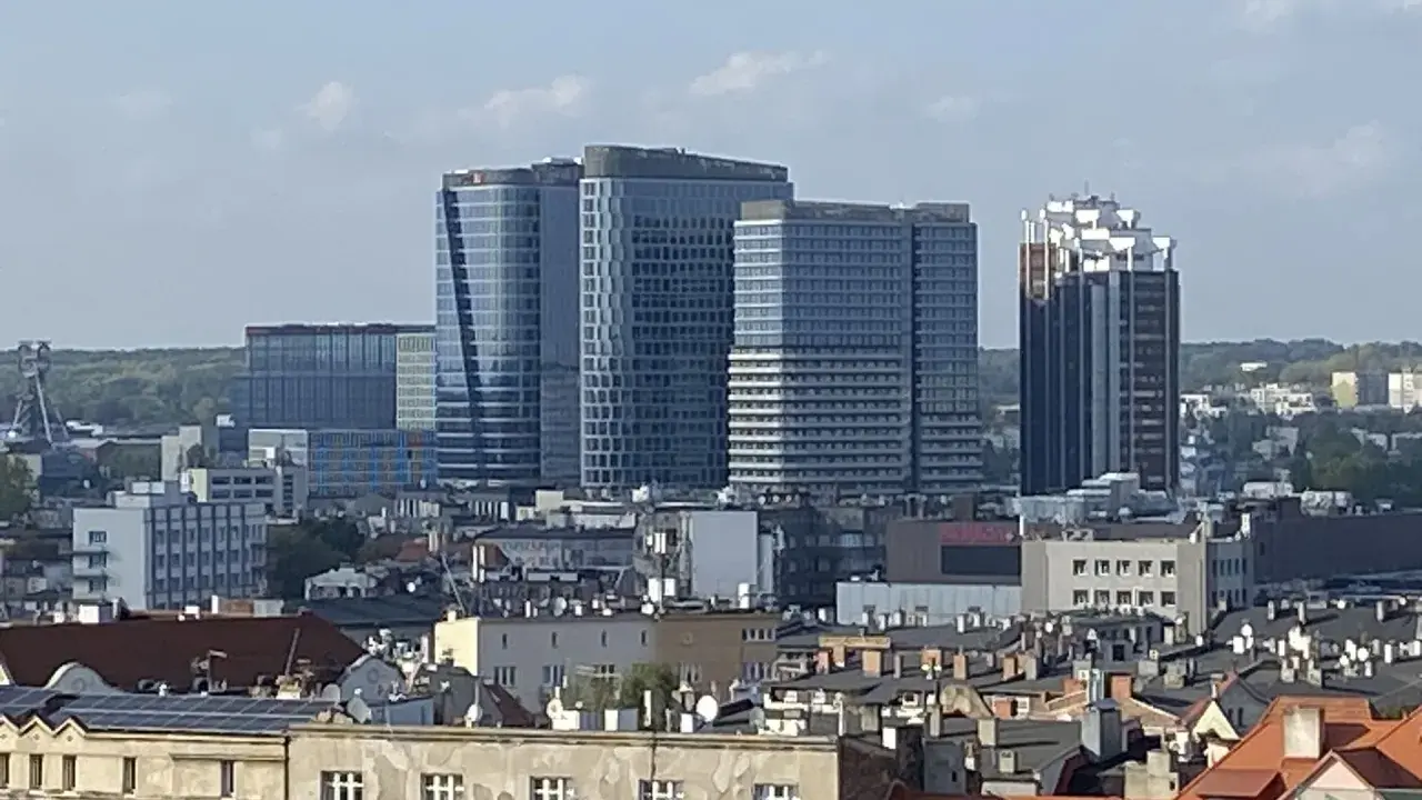 Nowoczesne wieżowce górują nad dachem kamienicy w największym mieście w Polsce.