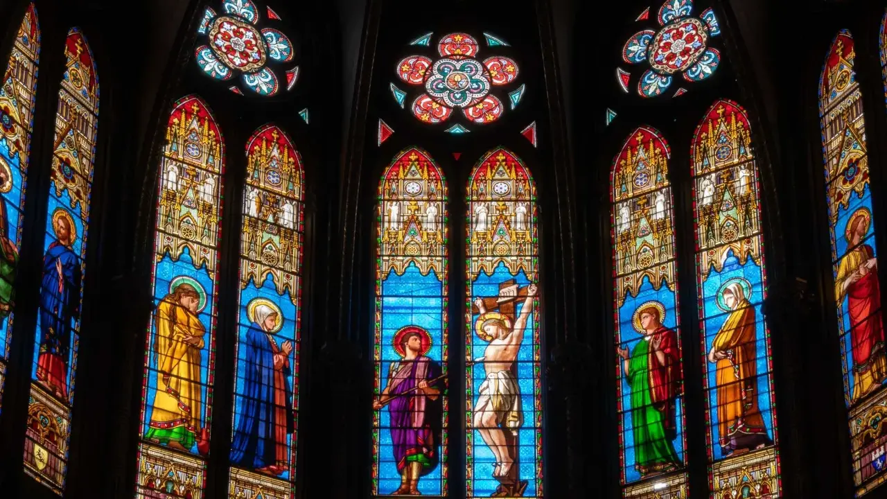 Magnifiques art vitraux d'une église, représentant des scènes bibliques avec des figures colorées sur fond bleu.