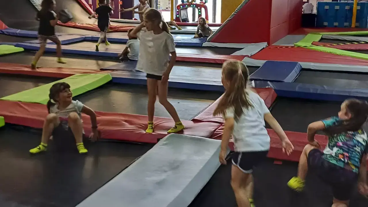 Dzieci skaczą na trampolinach w parku rozrywki. To świetne gorzów wielkopolski atrakcje dla dzieci, pełne radości i ruchu.