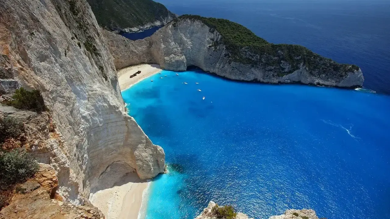 Widok na Navagio, słynną zatokę wraku w Grecji, z turkusową wodą i białymi klifami.