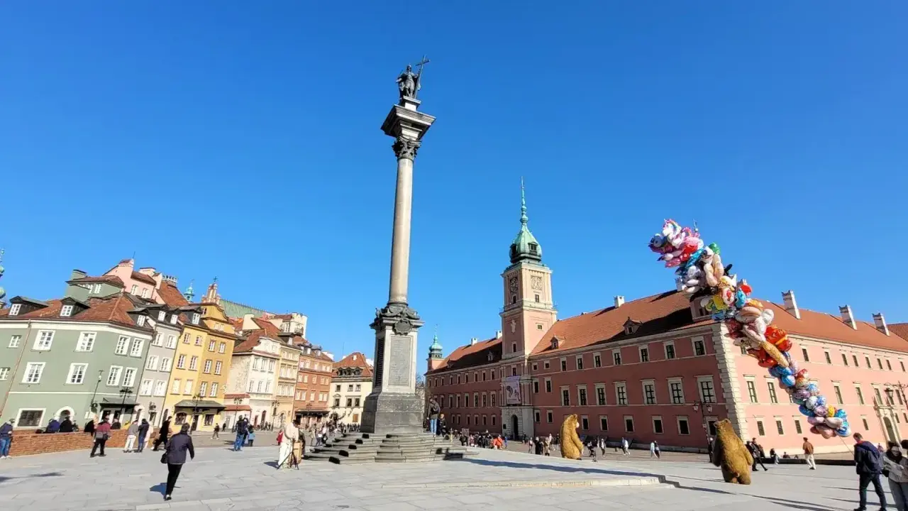 Kolumna Zygmunta i Zamek Królewski na placu w sercu starego miasta Warszawa. Balony unoszą się na błękitnym niebie.