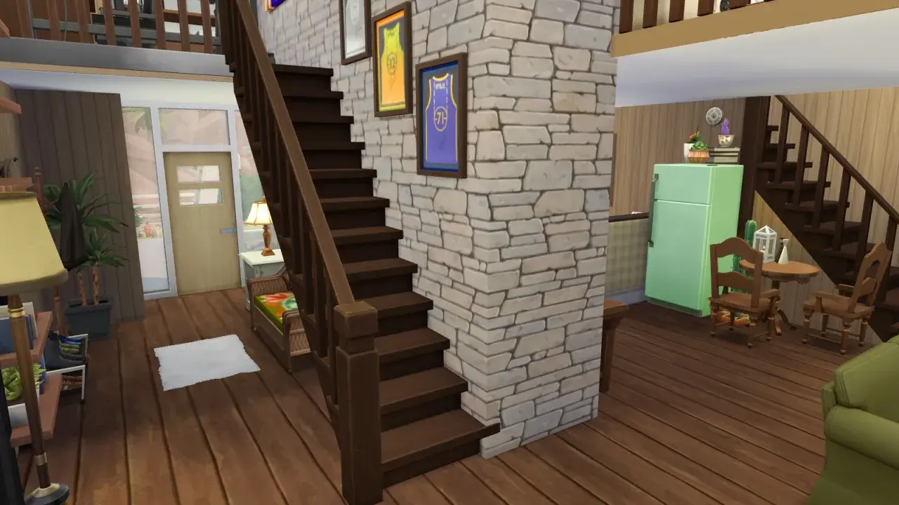 Wnętrze domu w The Sims 4: drewniane schody, kamienna ściana, lodówka i meble.
