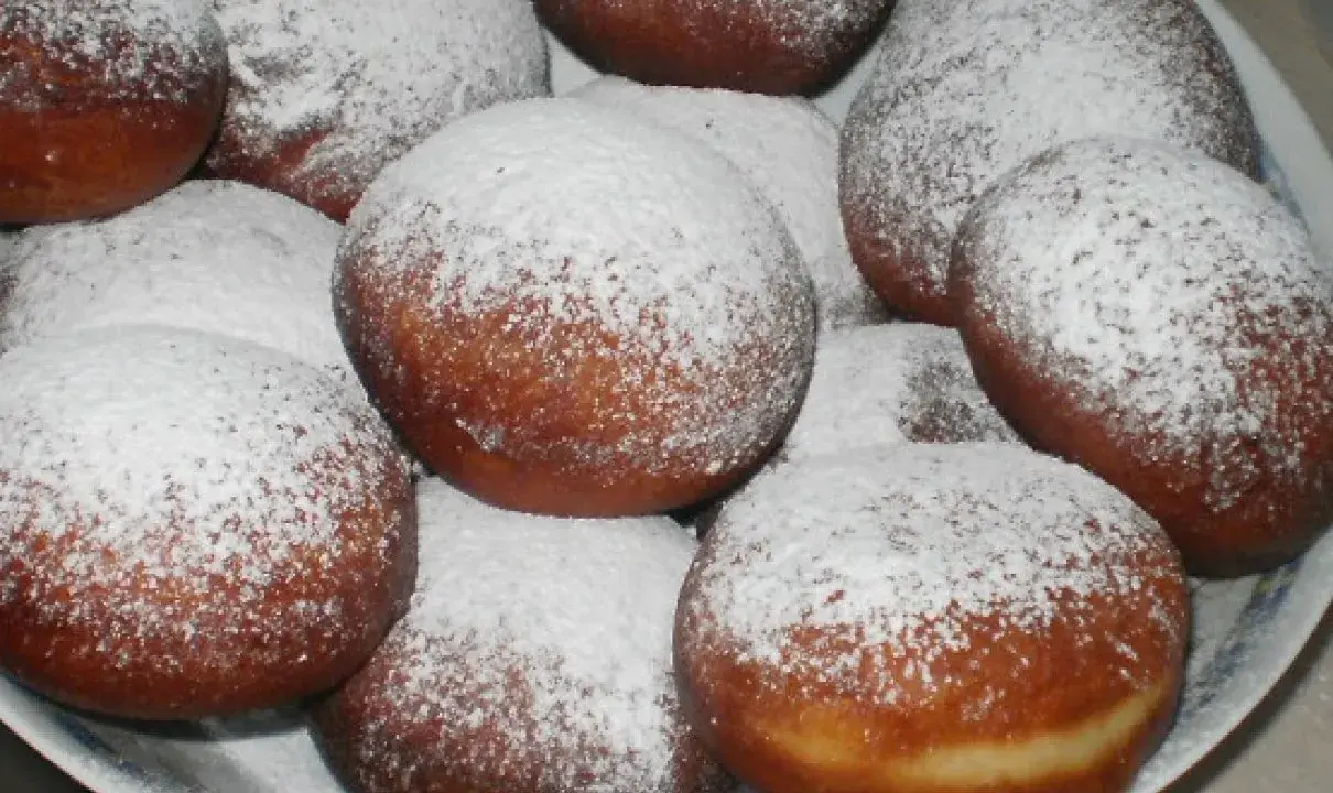 Pyszne, świeżo usmażone paczki posypane cukrem pudrem. Idealne, gdy zastanawiasz się, jak zrobić paczki na tłusty czwartek.