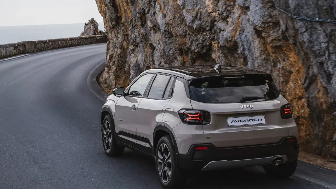 Nowy Jeep Avenger, jeden z najnowszych jeep modele, pokonuje krętą drogę nad morzem, wspinając się po skalistym zboczu.