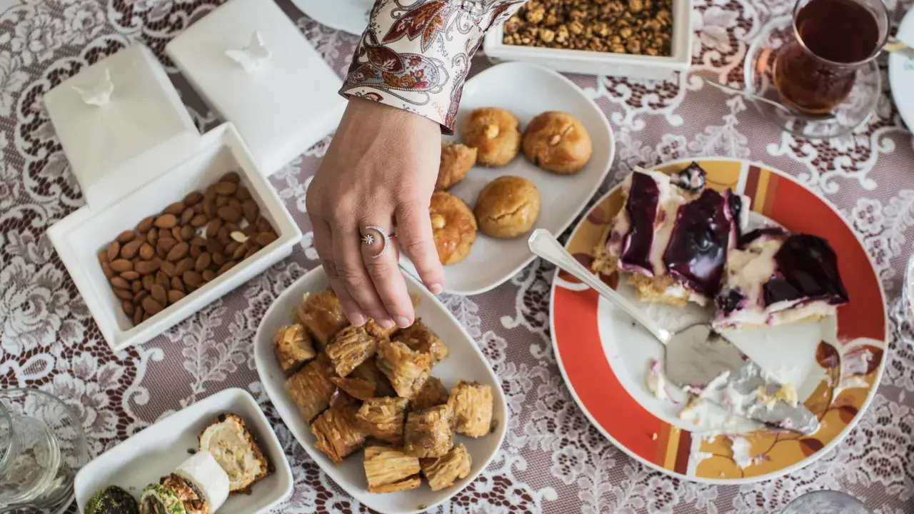 Ein Tisch voller Köstlichkeiten für das Ramadan Fest: Baklava, Kekse, Mandeln und ein Stück Kuchen.