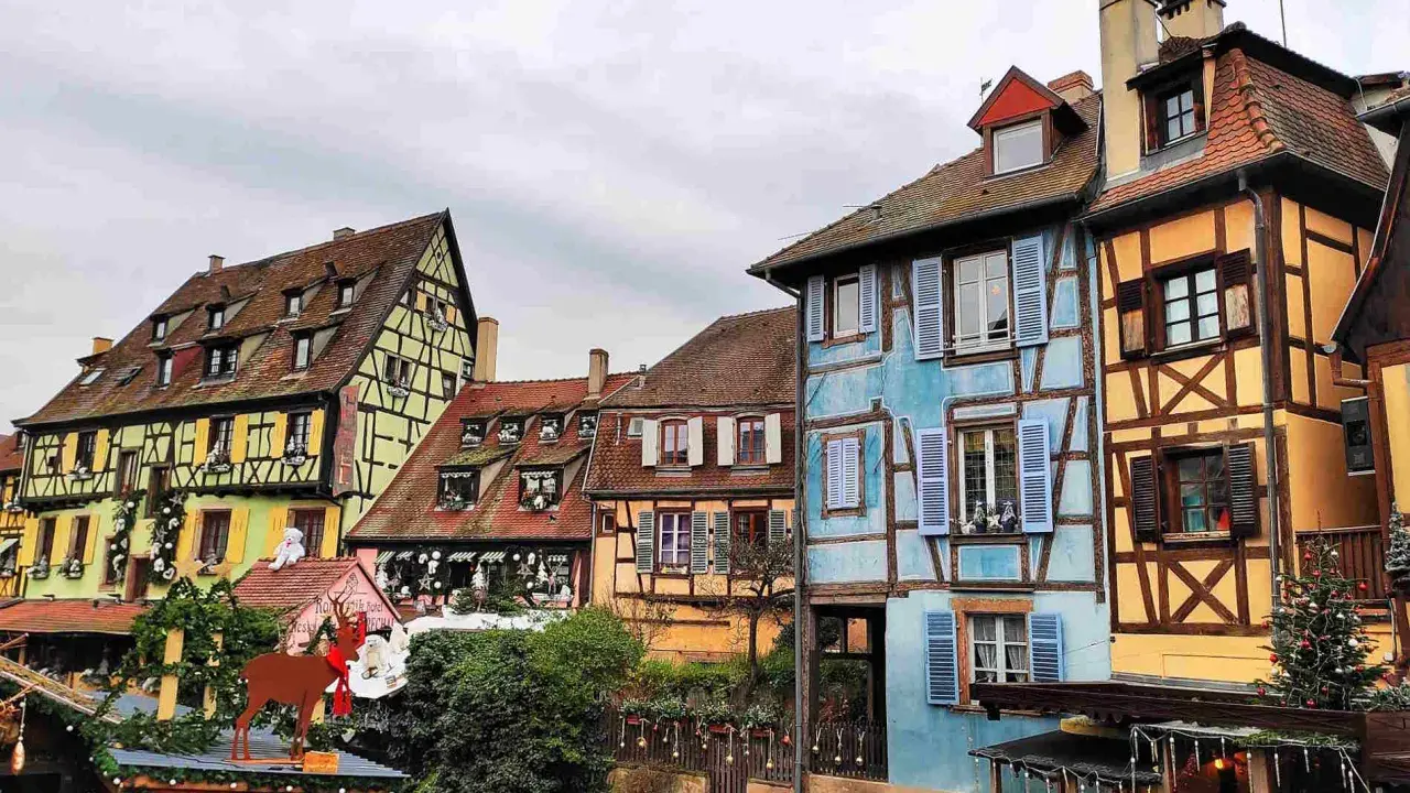 Case colorate e a graticcio lungo un canale, un'incantevole scena tra le città europee da visitare, con decorazioni natalizie.