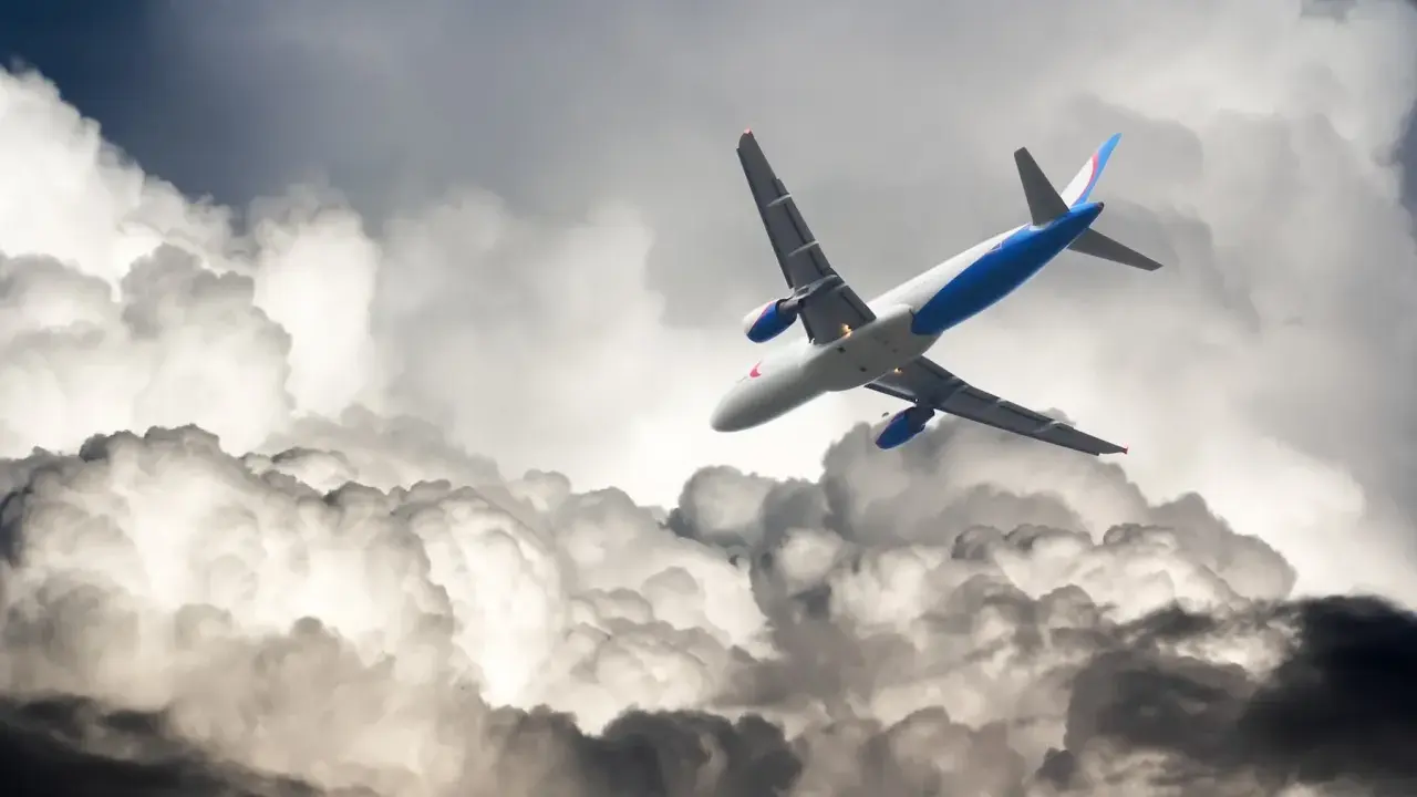 Flygplan kämpar sig fram genom mörka moln, en dramatisk scen av turbulens i luften.