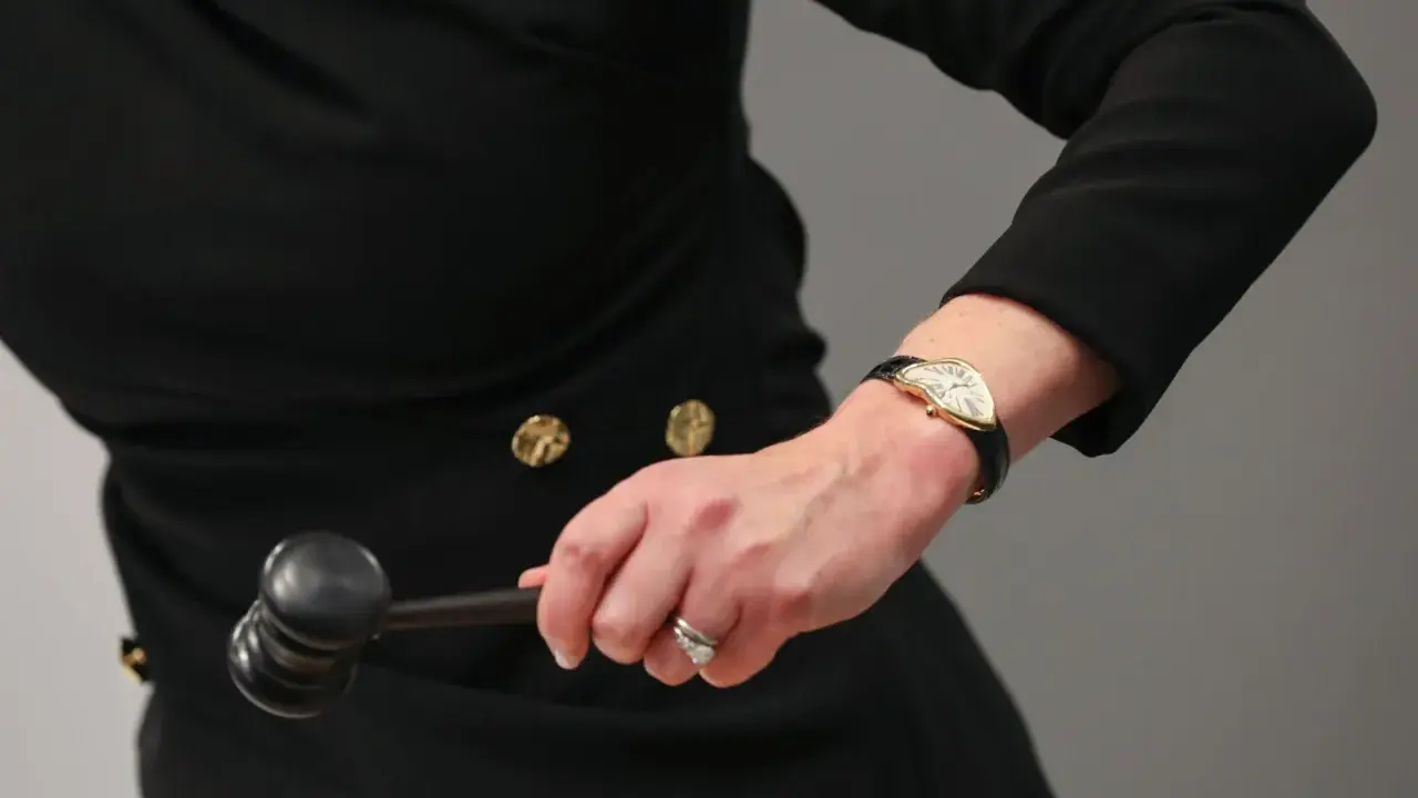 Auctioneer's hand with a gavel, ready to finalize an art loan.