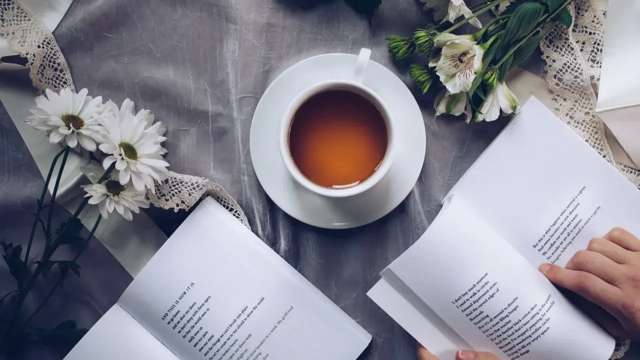 Kawa i kwiaty obok otwartych książek po angielsku online za darmo. Idealny sposób na relaks i naukę.