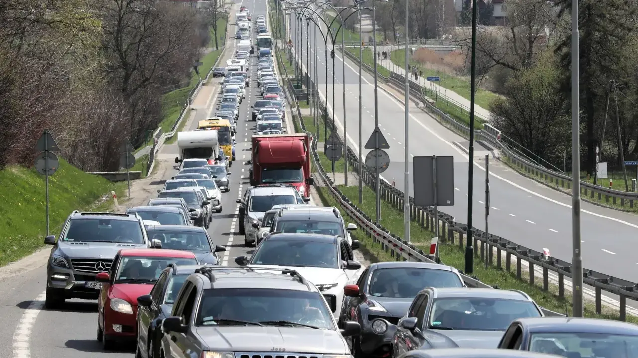 Korek na drodze, jak węzeł gordyjski, zablokował ruch. Samochody stoją w długiej kolejce, tworząc niekończący się rząd pojazdów.
