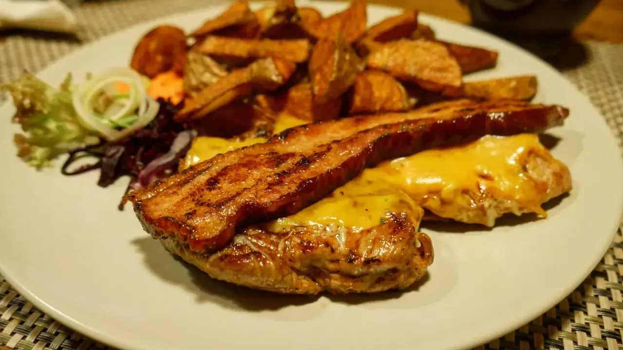 Pyszny burger z bekonem i serem, podany z frytkami i surówką. Smakuje jak w bacówce u Józka w Łodzi!
