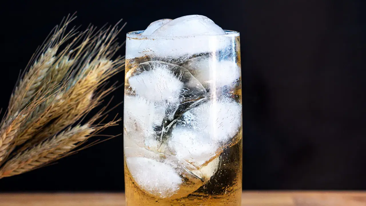 Ein erfrischender Whisky Soda mit viel Eis, daneben ein paar Ähren.