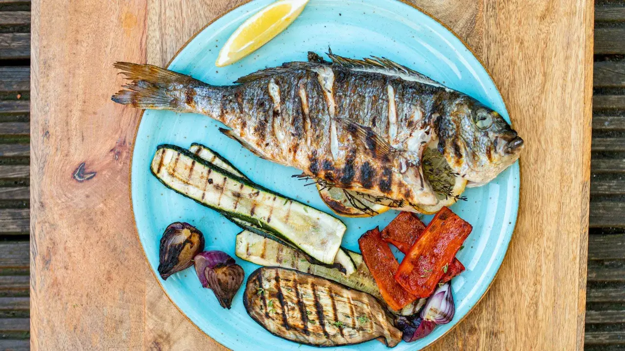 Gegrillte Dorade mit Zucchini, Aubergine, Paprika und Zwiebeln. Der frische Zitronenschnitz verspricht den vollen Dorade Geschmack.