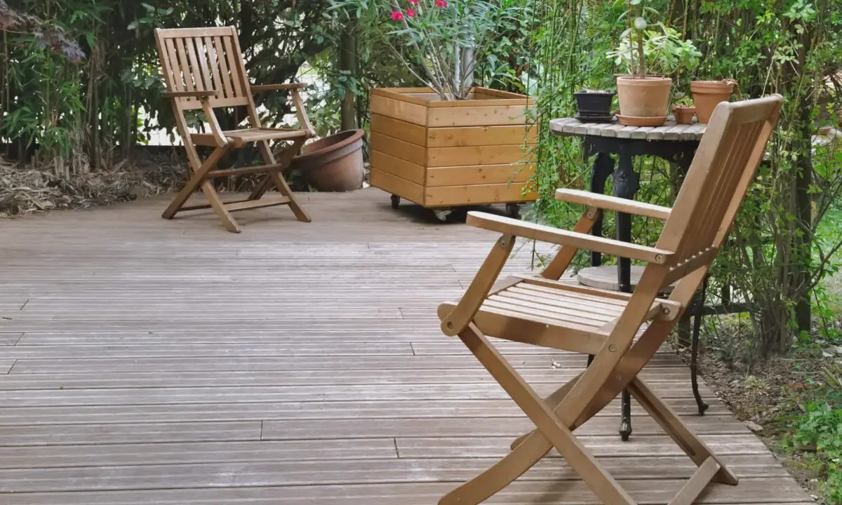 Deux chaises en bois sur une terrasse. Pour savoir comment protéger un meuble de l'humidité, pensez à un traitement hydrofuge.