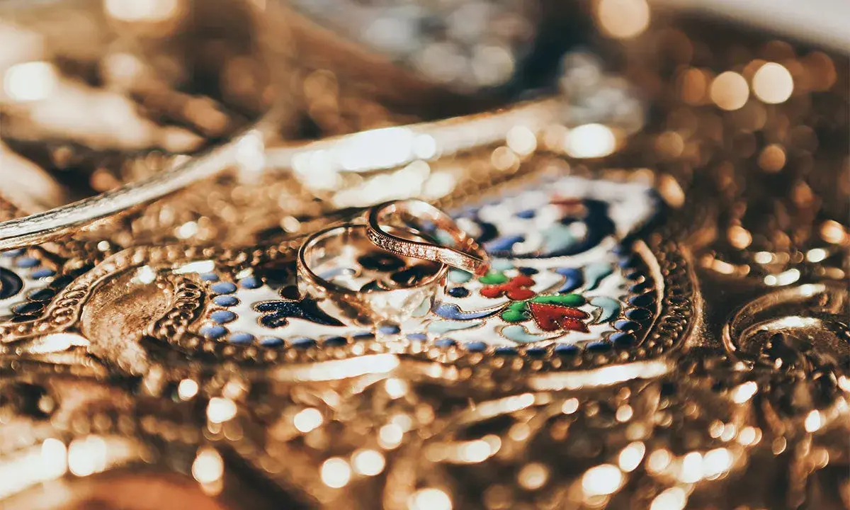 Due fedi nuziali, una con diamanti, su un prezioso scrigno decorato. Il loro valore, il vero carati significato.