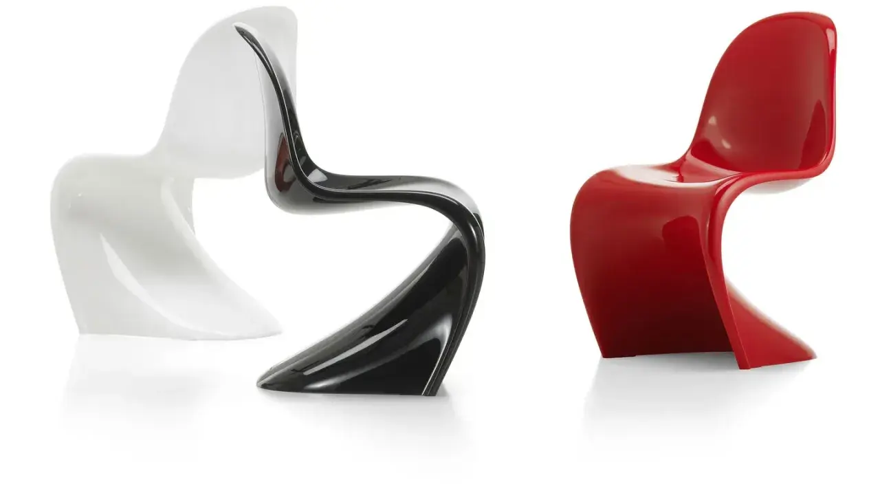 Tre sedie di design iconiche: una bianca, una nera lucida e una rossa brillante, con forme sinuose e moderne.
