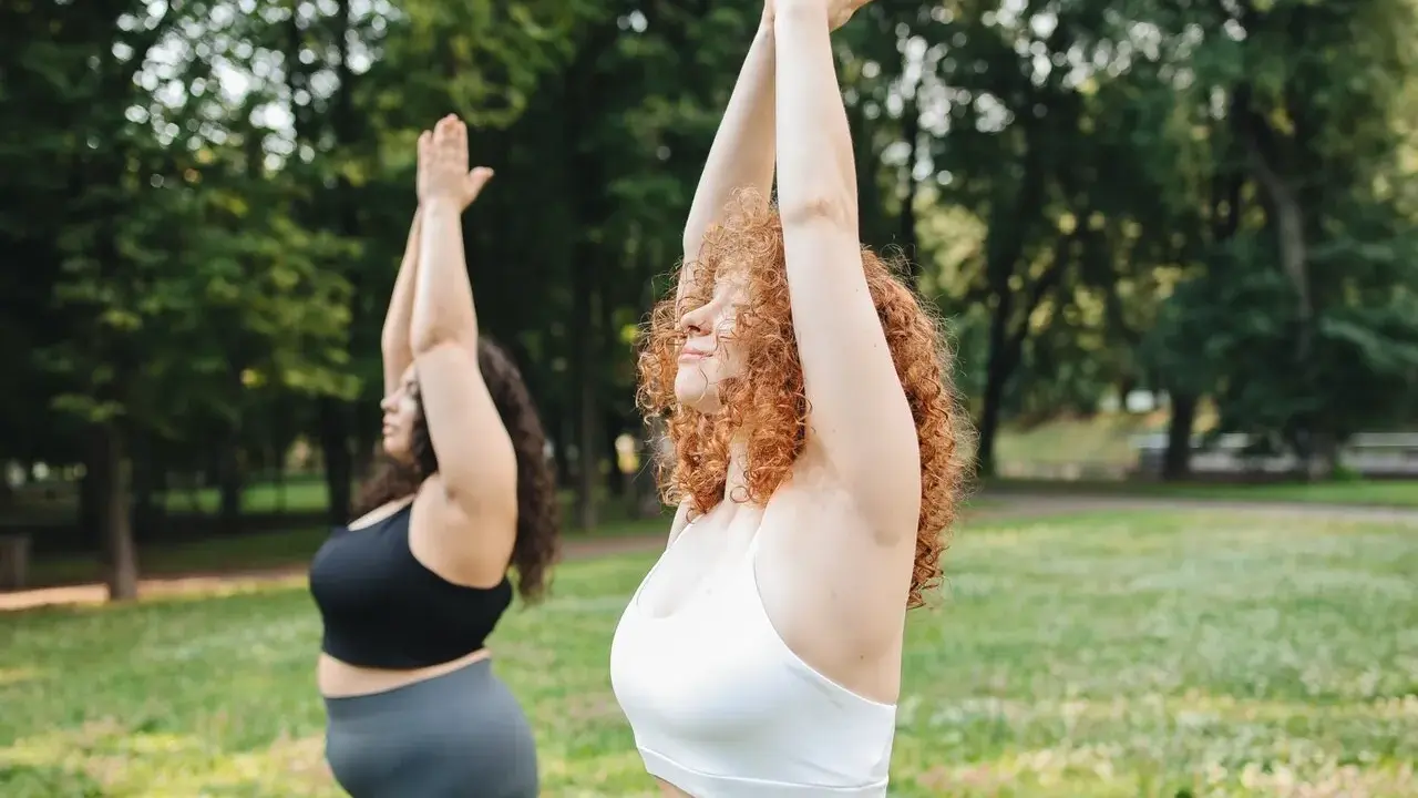 Dos mujeres realizan yoga en un parque. Se puede hacer ejercicio con la regla, sin importar el cuerpo.