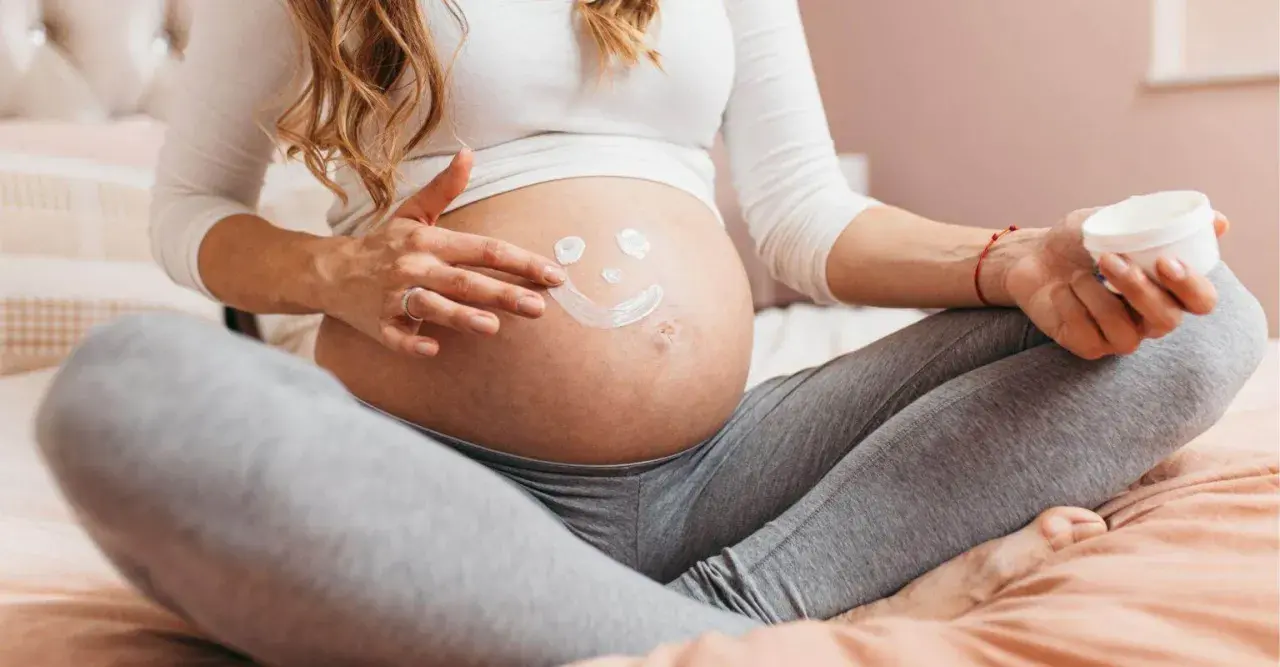 Ciężarna kobieta rysuje uśmiechniętą buźkę na brzuchu. Myśli o przyszłości, o zdrowiu dziecka i o tym, jak cenna jest krew pępowinowa.