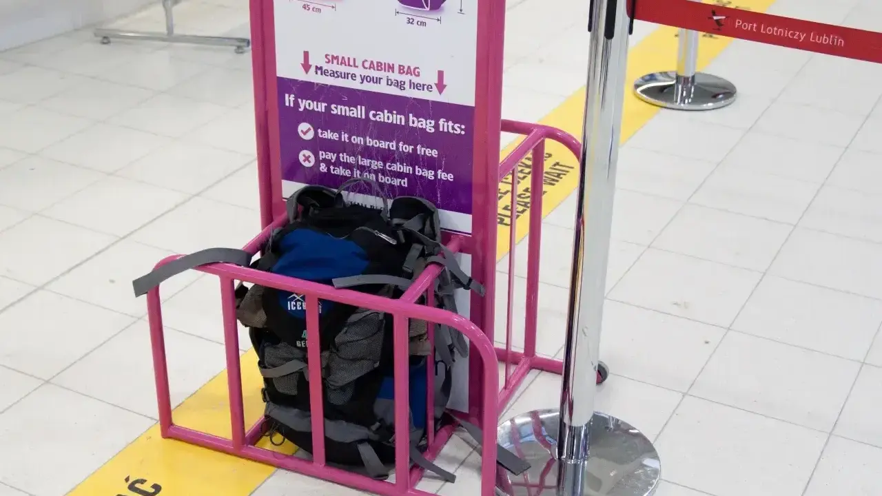 Wizzair leki w bagażu podręcznym? Sprawdź wymiary w różowym stojaku. Plecaki czekają na pomiar.