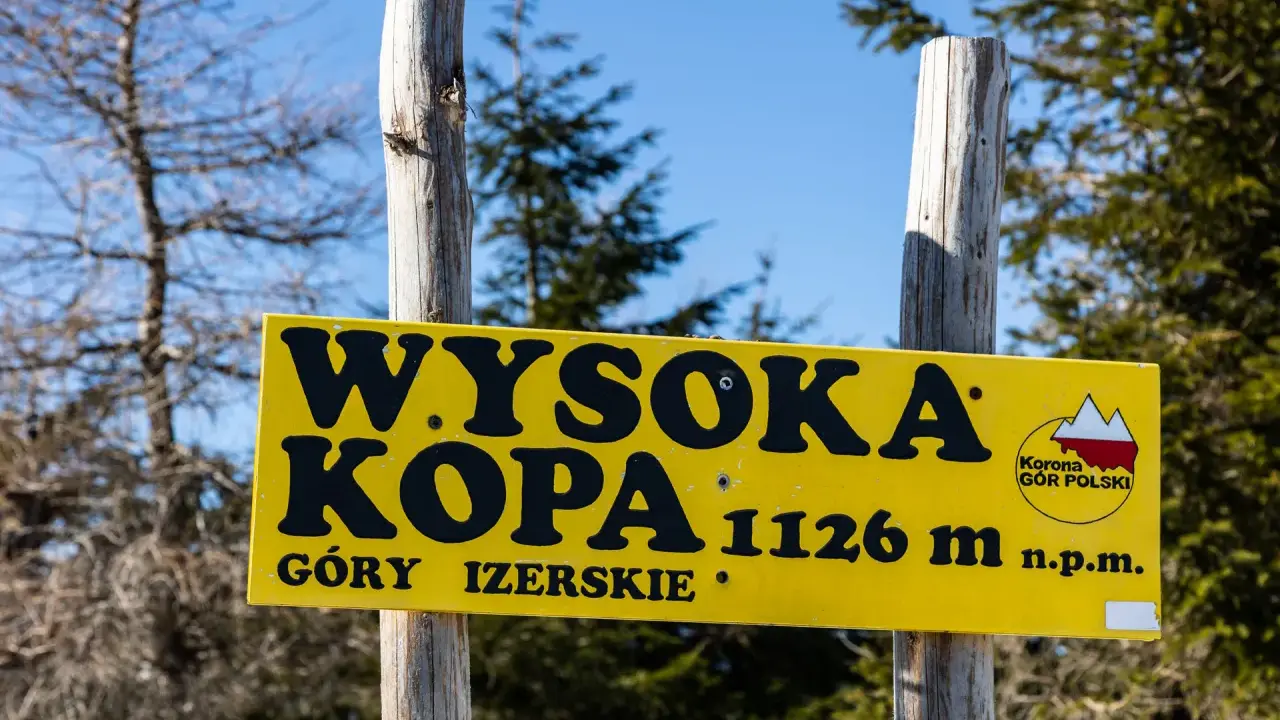 Żółta tablica informuje o szlaku na Wysoką Kopę (1126 m n.p.m.) w Górach Izerskich.