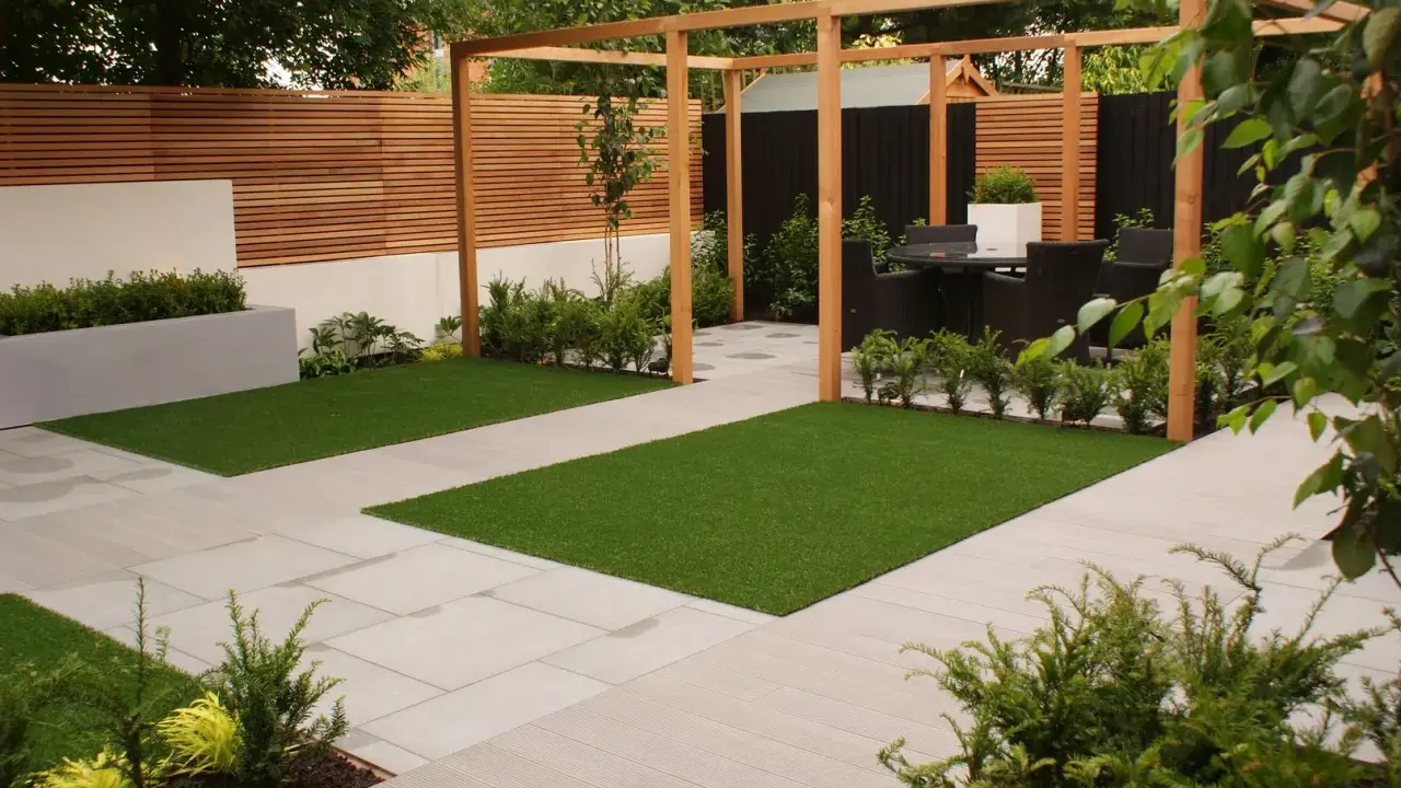 Un giardino moderno e cool con prato artificiale, pavimentazione chiara e pergolato in legno. Ideale per rilassarsi.