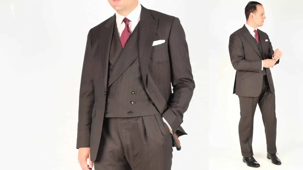 A man in a dark pinstripe suit, white shirt, and red patterned tie. He's adjusting his cuff, ready for a formal event.