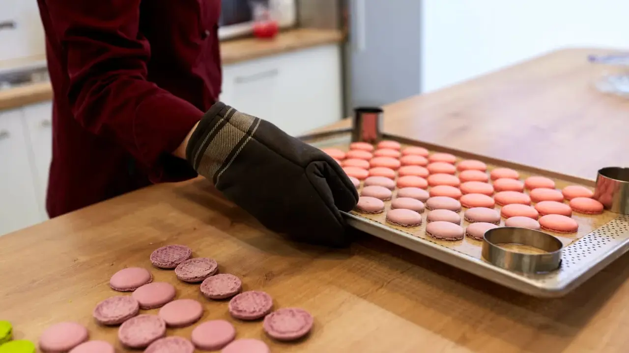 Préparation pour la cuisson macaron chaleur tournante : une plaque de macarons roses et roses est sortie du four.