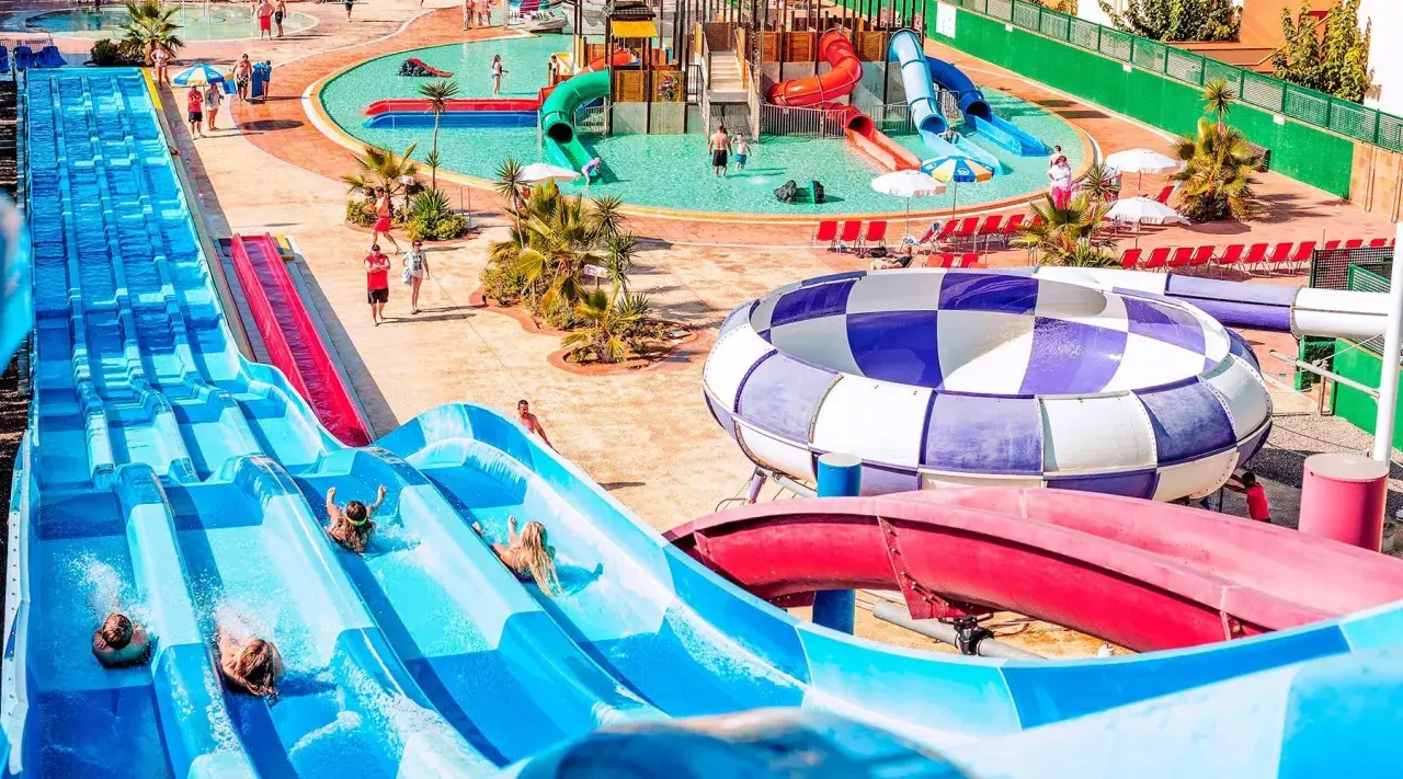 ¡Diversión acuática en Ibiza con niños! Toboganes azules y una piscina de olas para disfrutar del verano.