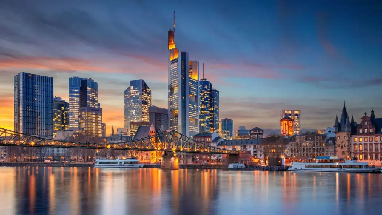 Frankfurter Skyline bei Sonnenuntergang mit Main und Brücke.