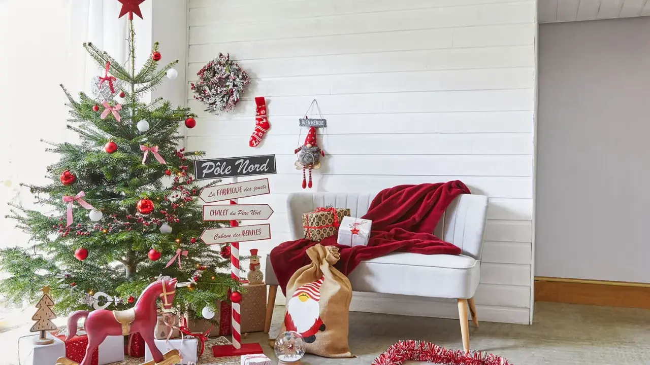 Un sapin décoré, des cadeaux et un fauteuil rouge invitent à faire des décorations de Noël. Un panneau "Pôle Nord" indique la direction.