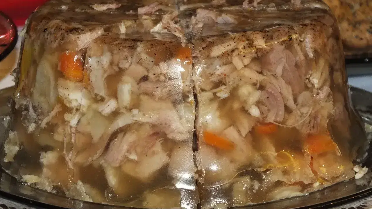 Pyszna galareta wieprzowa z kawałkami mięsa i warzyw, przygotowana na specjalną okazję.