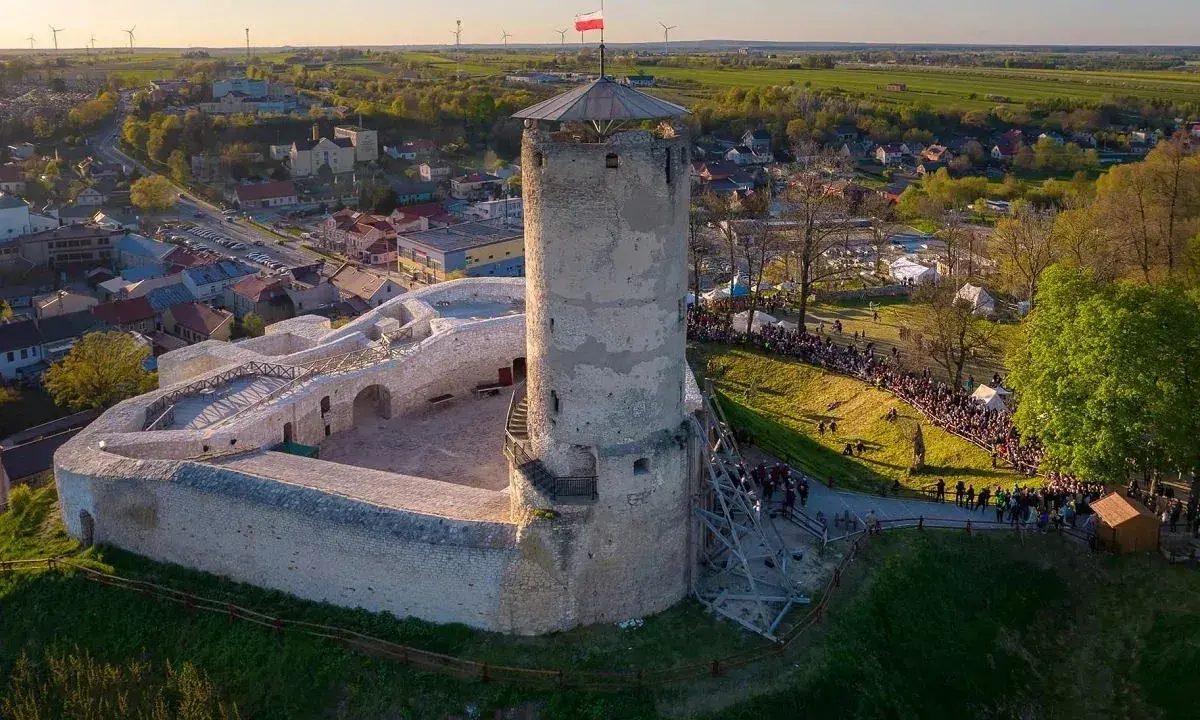 Iłża zamek z wieżą i murami obronnymi, otoczony przez tłumy ludzi podczas wydarzenia.