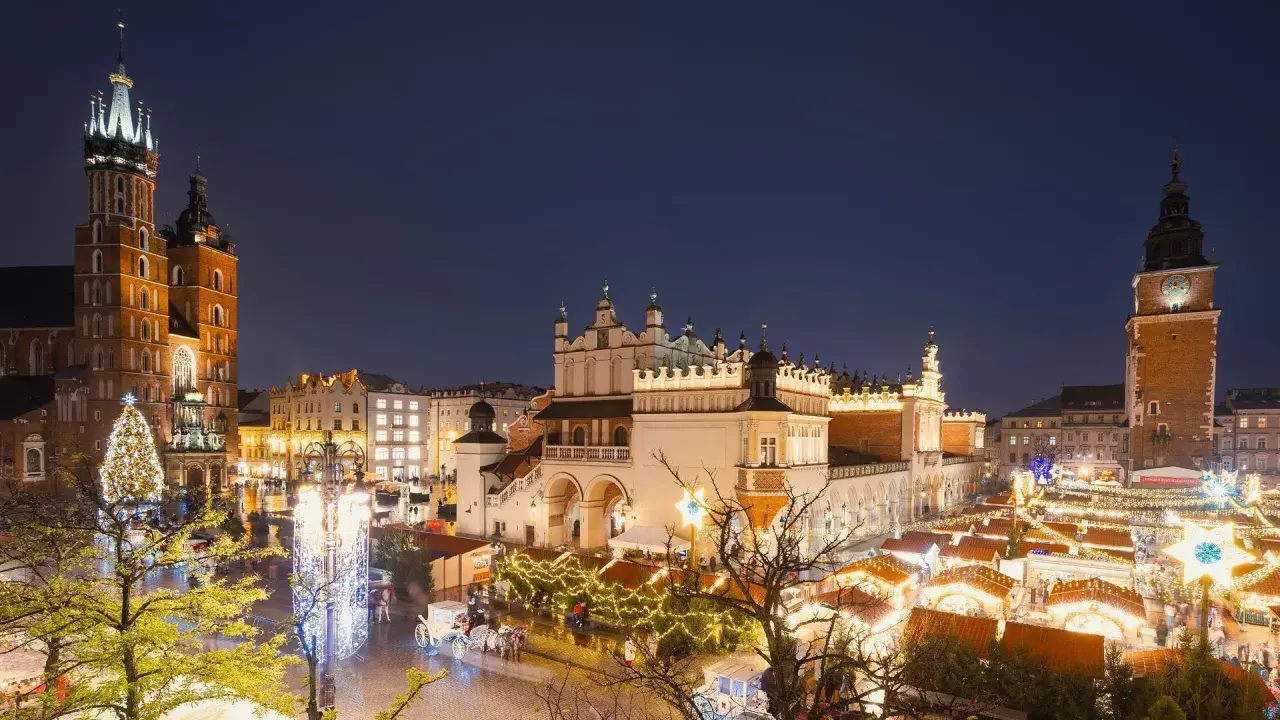 Kraków atrakcje zimą: Rynek Główny nocą, iluminacje świąteczne, Sukiennice, Kościół Mariacki i wieża ratuszowa.