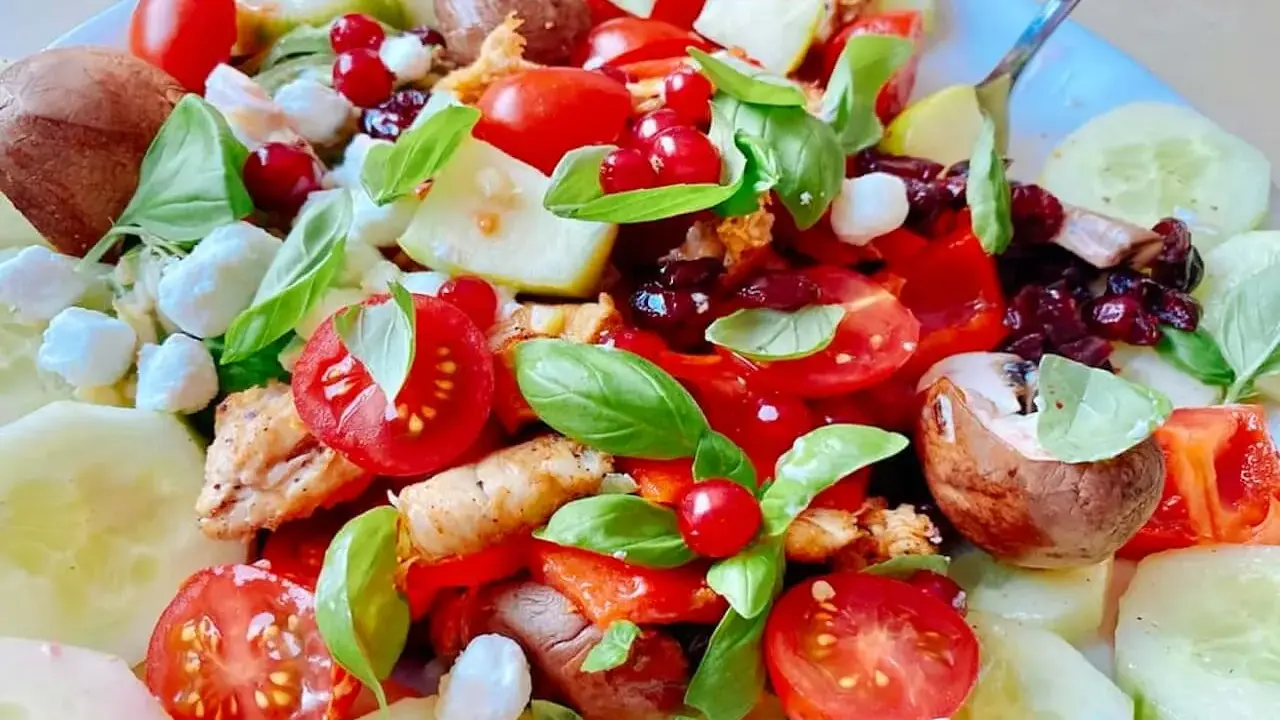 Salade colorée avec poulet, tomates, concombre, mozzarella et fruits rouges. Une excellente idée repas froid midi, fraîche et savoureuse.
