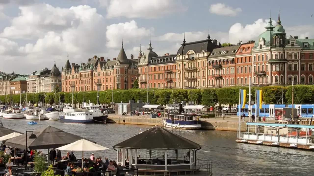 En dag i Stockholm vid vattnet med vackra byggnader, båtar och uteserveringar.