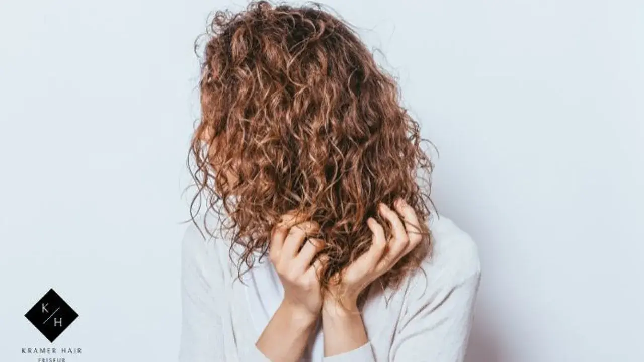 Frauen mit einer voluminösen Dauerwelle, die ihre Hände durch die Locken gleiten lassen.
