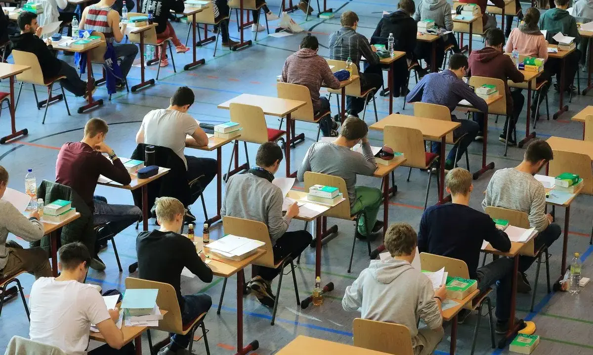 Schüler konzentriert bei einer Prüfung. Die Wortherkunft des Abiturs ist lateinisch, was "weggehen" bedeutet.