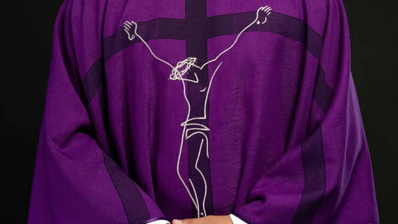 Fioletowa szata liturgiczna z haftowanym wizerunkiem Jezusa na krzyżu.