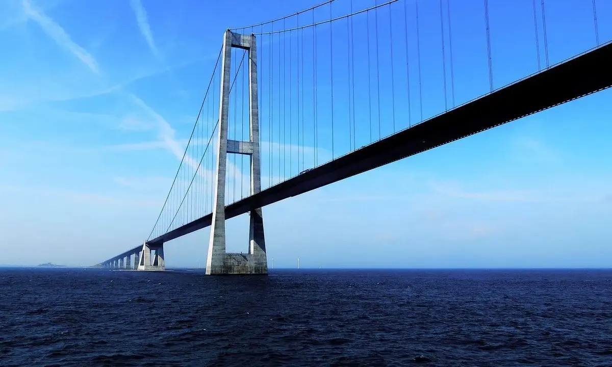 El puente del Gran Belt se extiende majestuosamente sobre el mar azul bajo un cielo despejado.